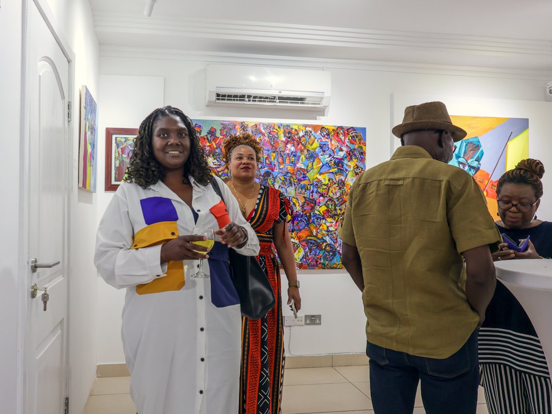 A guest smiling with a glass of wine during the opening