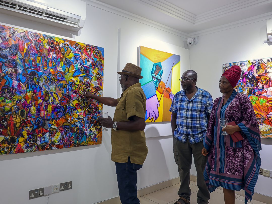 A guest pointing out details in a crowded, colourful canvas